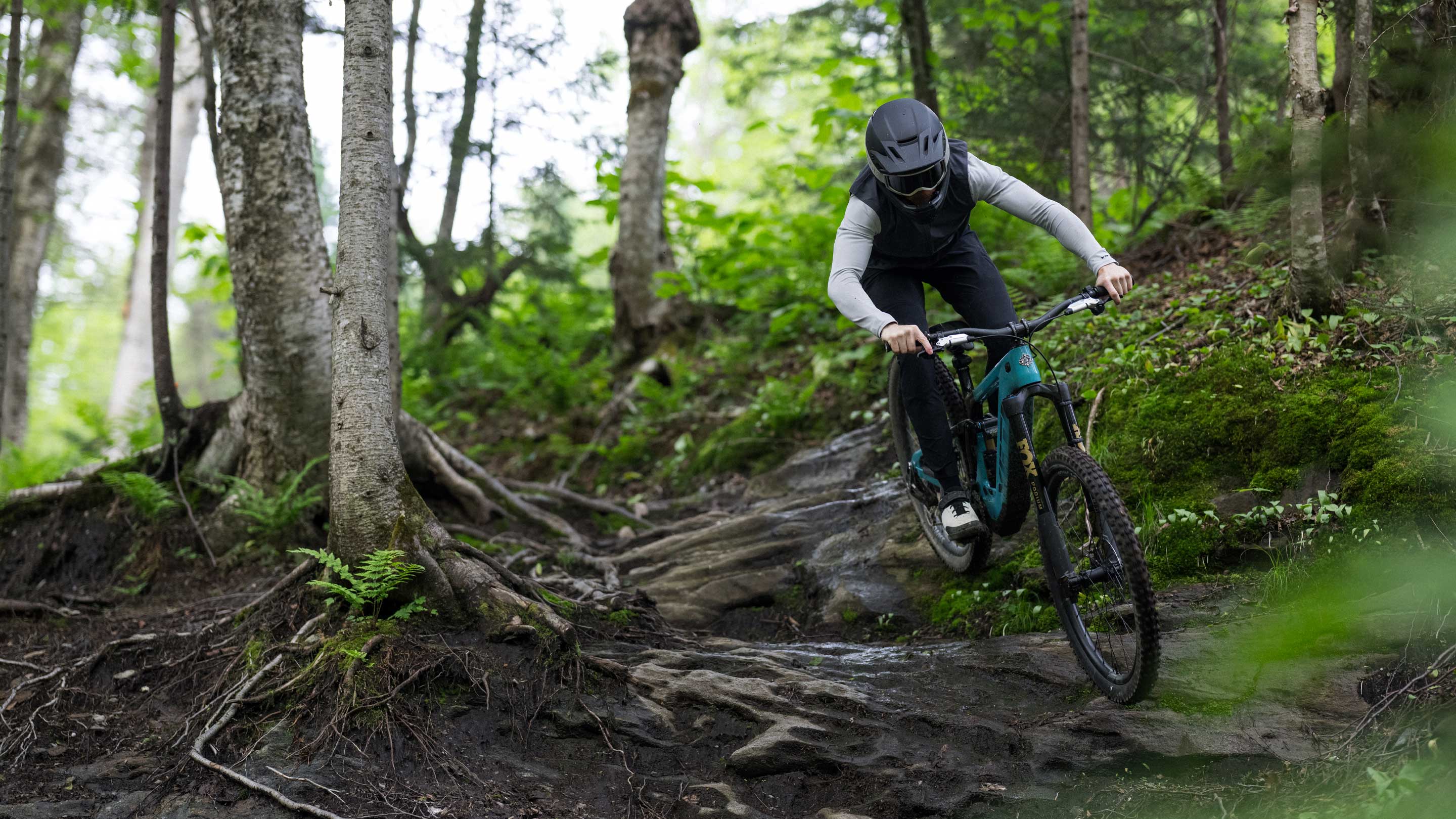 Yeti LTe eMTB being ridden over a rooty corner on a mountain bike trail