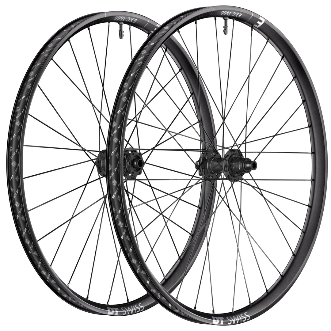 Pair of DT Swiss EXC 1500 enduro mountain bike wheels with carbon fibre rims on a white background