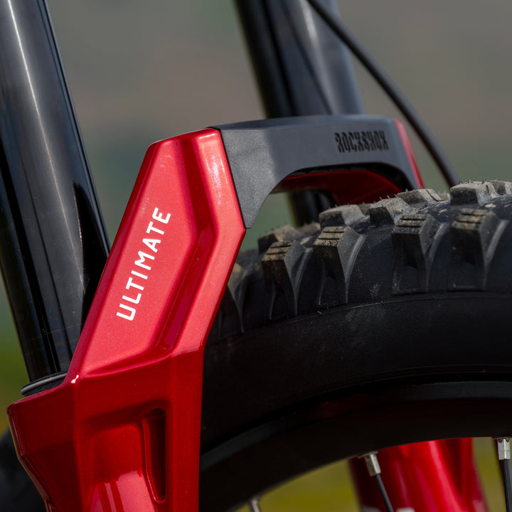 Close-up of a red ROCKSHOX Zeb Ultimate fork on a mountain bike, showing the brand name &