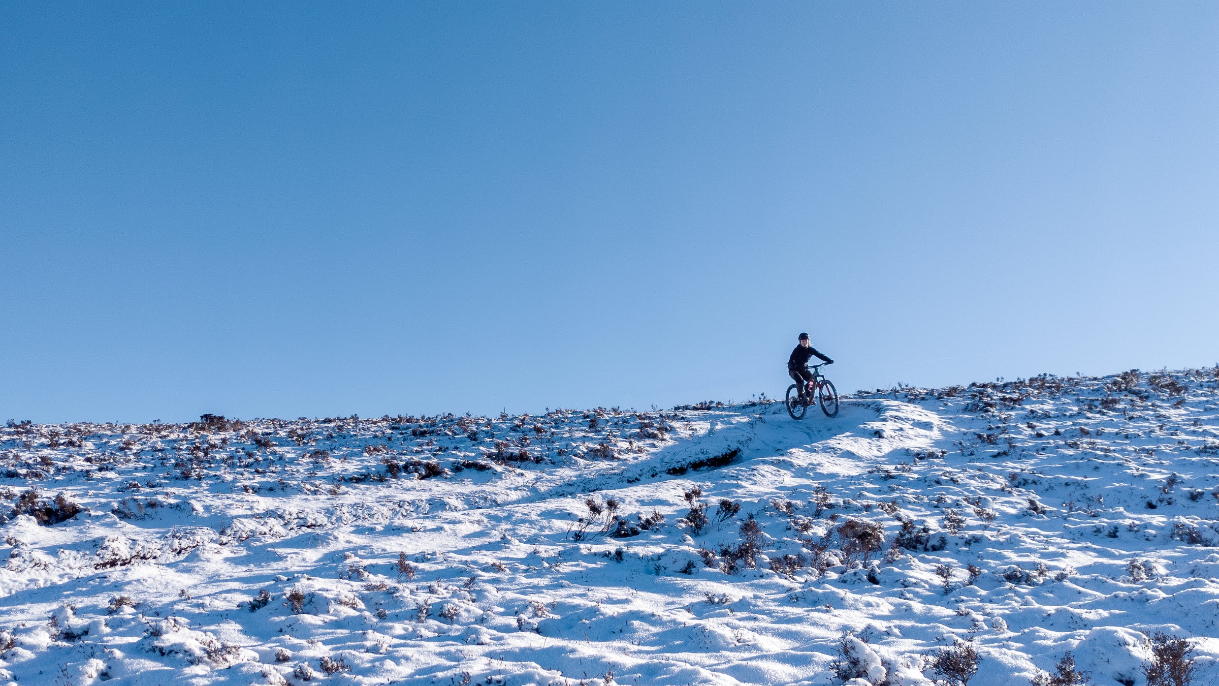 Mountainbiker riding in the Innerleithen snow